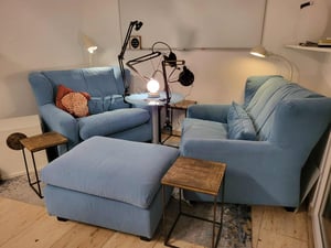 Sofas, Hocker und kleine Tische, in der Mitte Tisch mit Podcast-Equipment