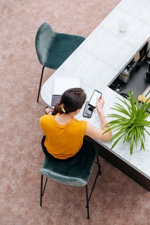 Geschäftsfrau an einem Tisch mit Laptop und Handy