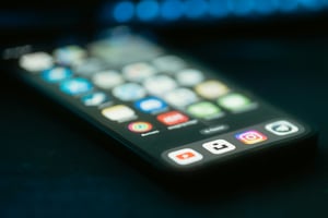 liegendes Handy mit unscharfen SoMe-Icons